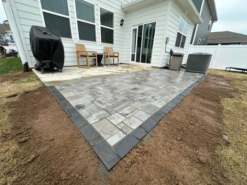 Paver patio installation beside a home